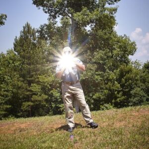 یک مرد که با استفاده از آلومینیوم یک آینه خورشیدی ساخته و نور آن را منعکس می‌کند.